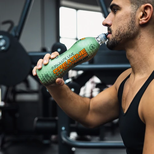 Edzőtermi edzés közben Absolute Live kreatin + L- glutaminos sportitalt fogyasztó sportoló